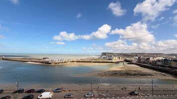 A coastal town with a beach, promenade, and a view of the sea.