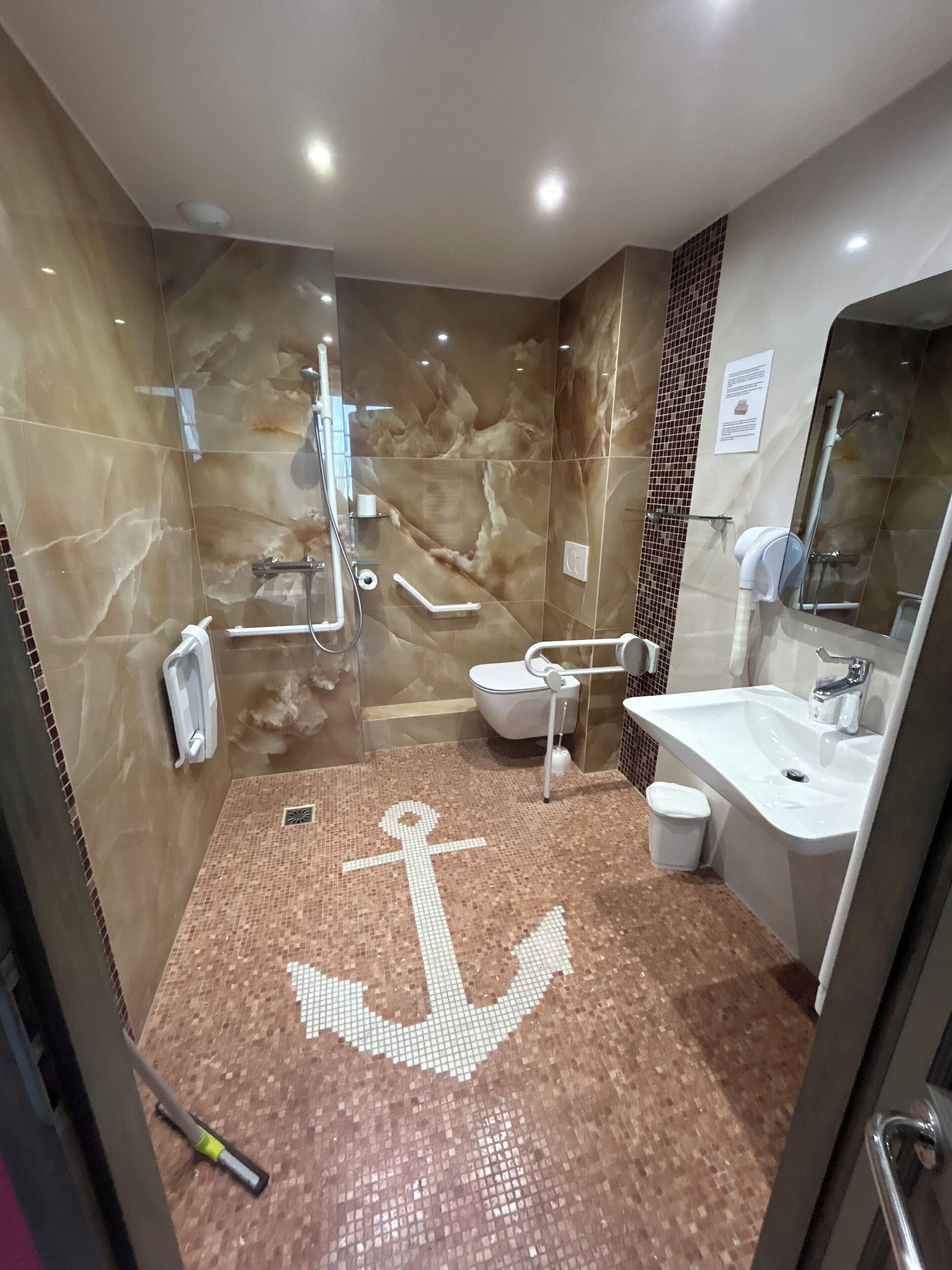 Ein Badezimmer mit einem großen Spiegel, einem Waschbecken und einer Duschkabine.