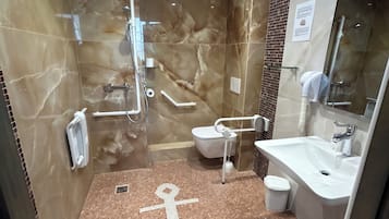 Ein Badezimmer mit einem großen Spiegel, einem Waschbecken und einer Duschkabine.