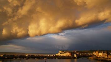 Une ville côtière dotée d’un port, de bâtiments et d’un ciel nuageux.