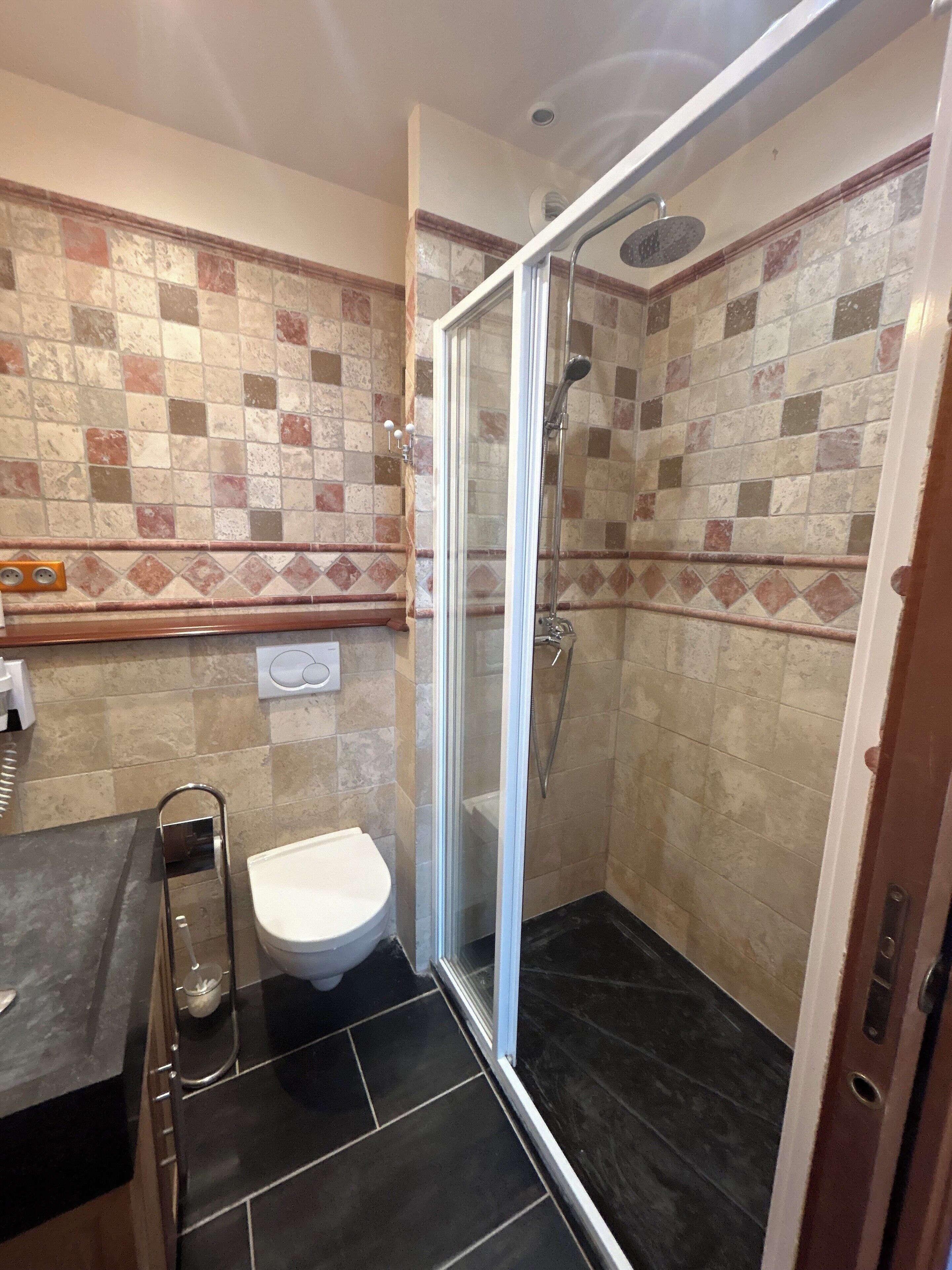 A bathroom with a shower, toilet, and sink.