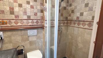 A bathroom with a shower, toilet, and sink.