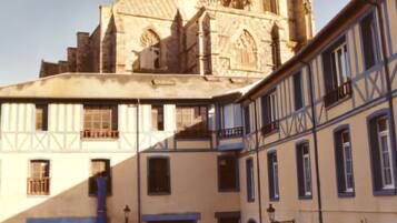 A historic building with a prominent tower and a courtyard.