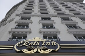The exterior of Reis Inn Hotel in Istanbul, featuring a classical architectural style with multiple balconies and a prominent sign.