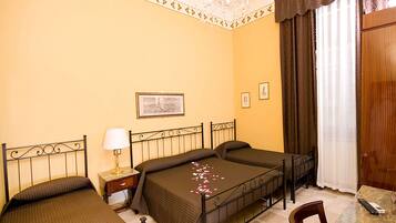 Ein Hotelzimmer mit Bett, Schreibtisch, Sessel, Lampe und einer Chandelier.