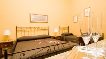 A hotel room with a bed, bedside tables, and two empty glasses on a tray.