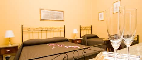 Habitación de hotel con cama, mesitas de noche y dos vasos vacíos sobre una bandeja.