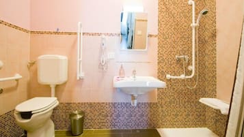 A bathroom with a toilet, sink, and shower.
