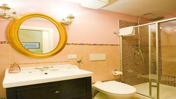 Une salle de bain équipée d’un lavabo, d’un miroir, de toilettes et d’une douche.