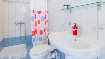 A bathroom with a bathtub, toilet, and sink.
