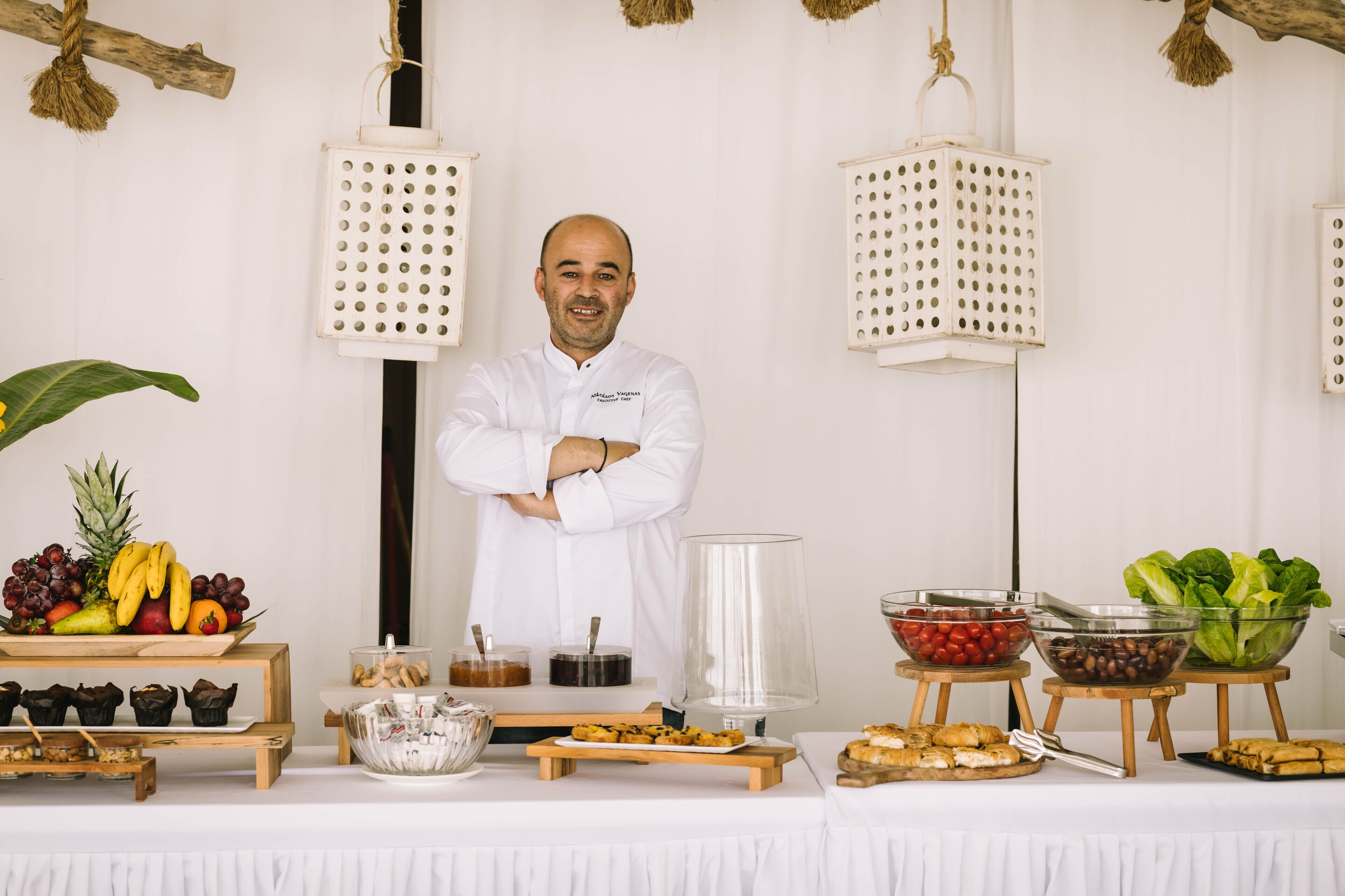 Una mesa de buffet con diferentes tipos de comida y una persona de pie frente a ella.