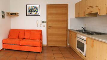 A compact kitchen with a stove, oven, and a small dining area.