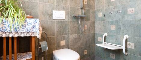 A bathroom with a toilet, a shower, and a sink.