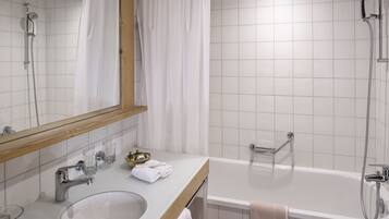 Un bany amb un lavabo blanc, mirall i plat de dutxa.