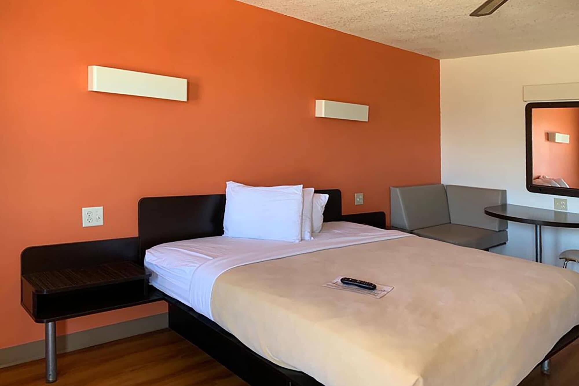 A hotel room with a bed, a desk, and a chair.
