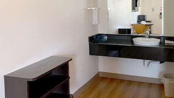 Un baño moderno con un tocador negro, un lavabo blanco y un espejo.