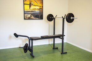 Un gimnasio con una prensa de banca y una estructura para sentadillas.
