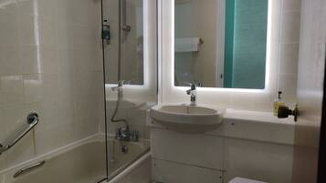 Ein Badezimmer mit Duschkabine, Waschbecken und Toilette.