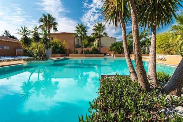 Una piscina al aire libre de temporada, sillones reclinables de piscina
