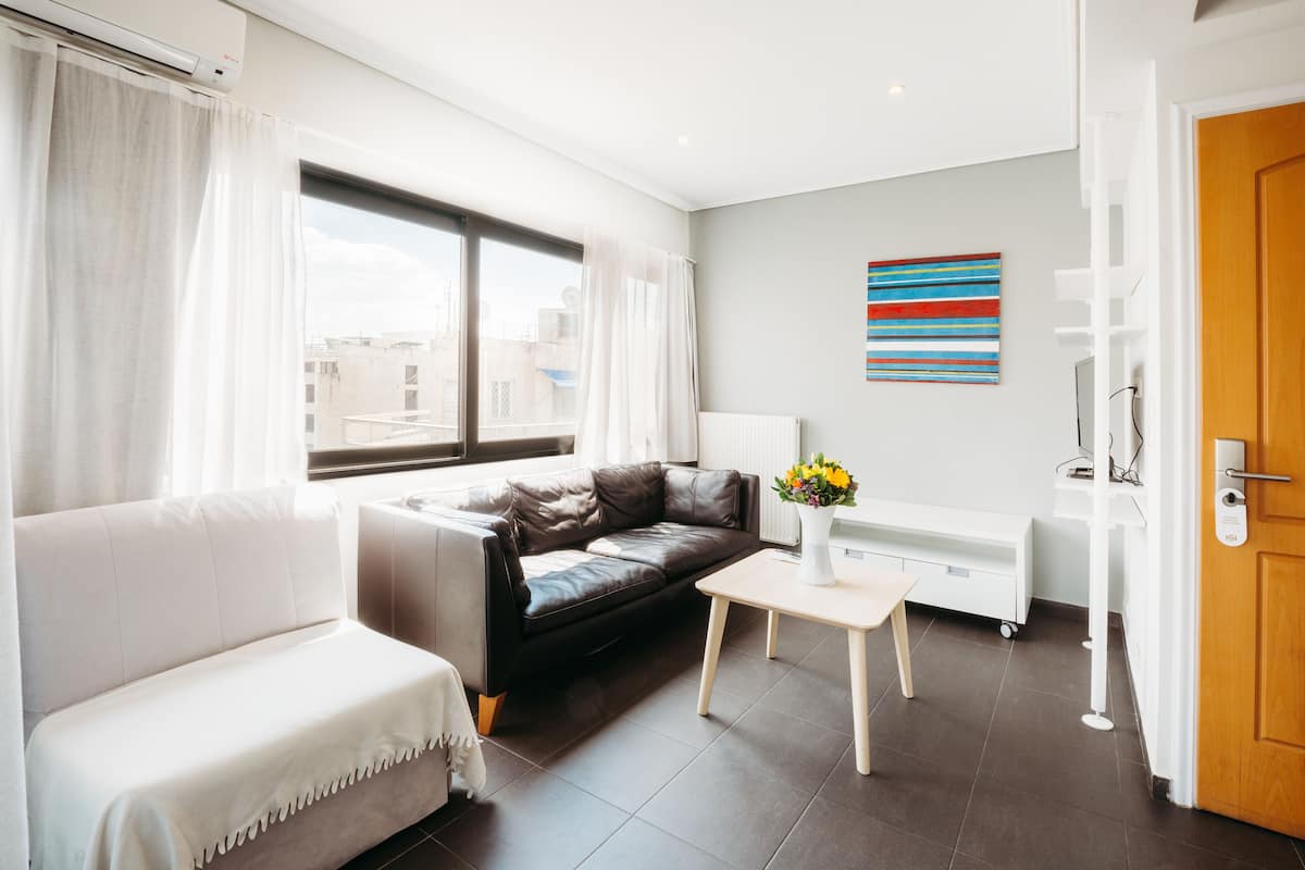 Suite familiar (Acropolis View & Dining Terrace) | Sala de estar | Televisión LED de 14 pulgadas con canales por cable y libros
