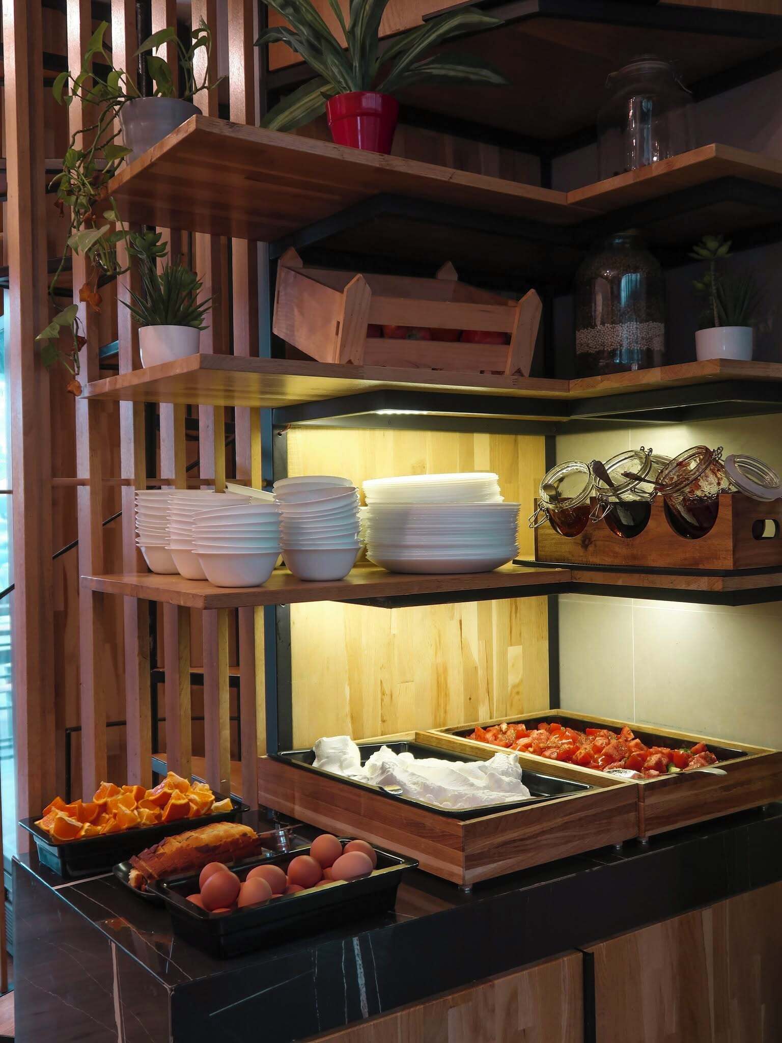 A buffet setup with various food items, including fruits, vegetables, and prepared dishes.
