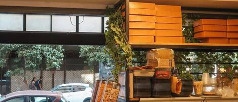 A restaurant interior with a buffet counter, seating area, and a window view.