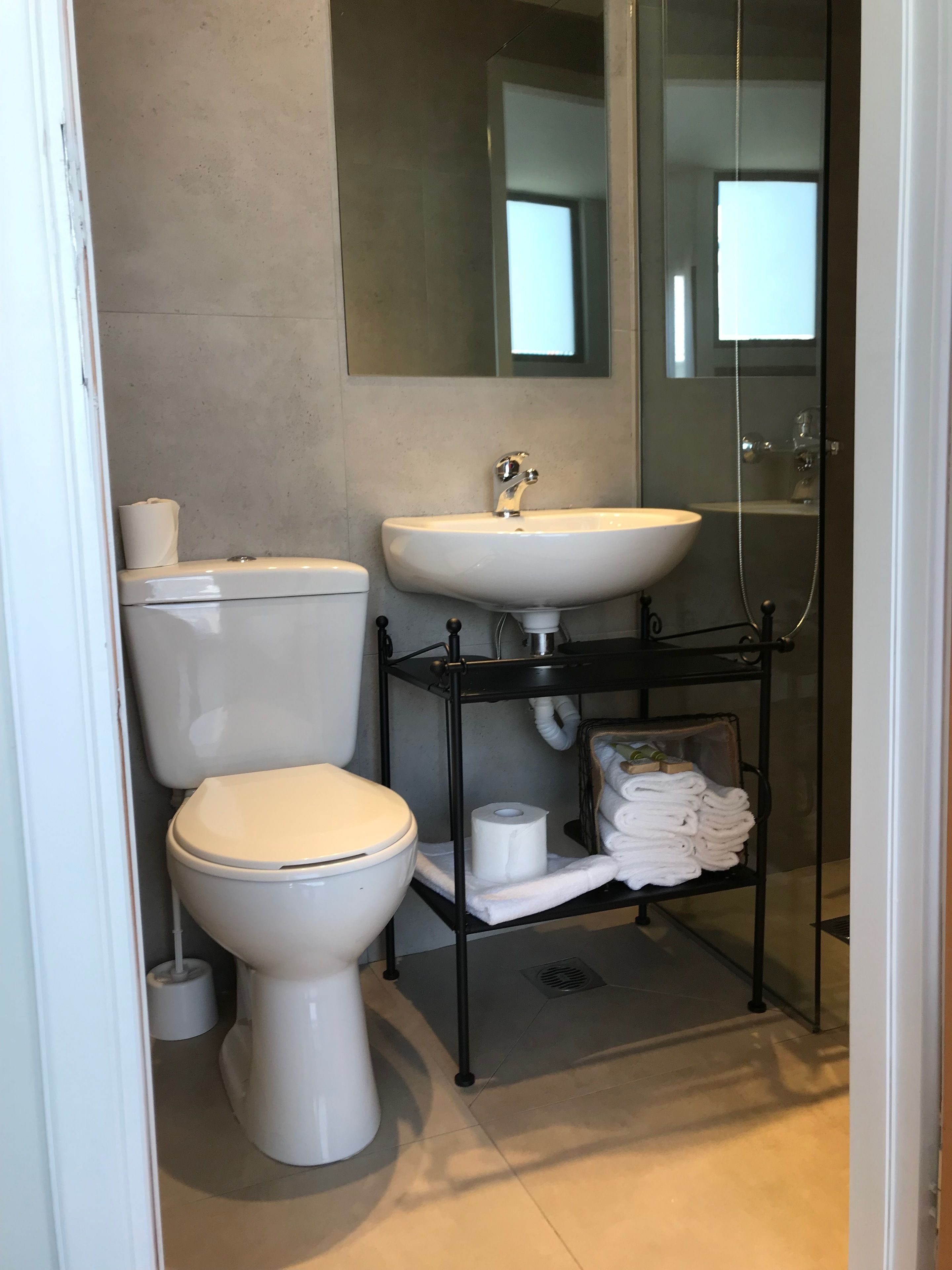 Une salle de bain moderne équipée de toilettes, d’un lavabo et d’une douche.