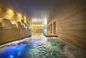 Una piscina techada, sillones reclinables de piscina
