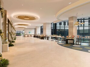 A spacious hotel lobby with a long reception desk, large windows, and a modern ceiling design. - Pullman New Delhi Aerocity Hotel (New Delhi)
