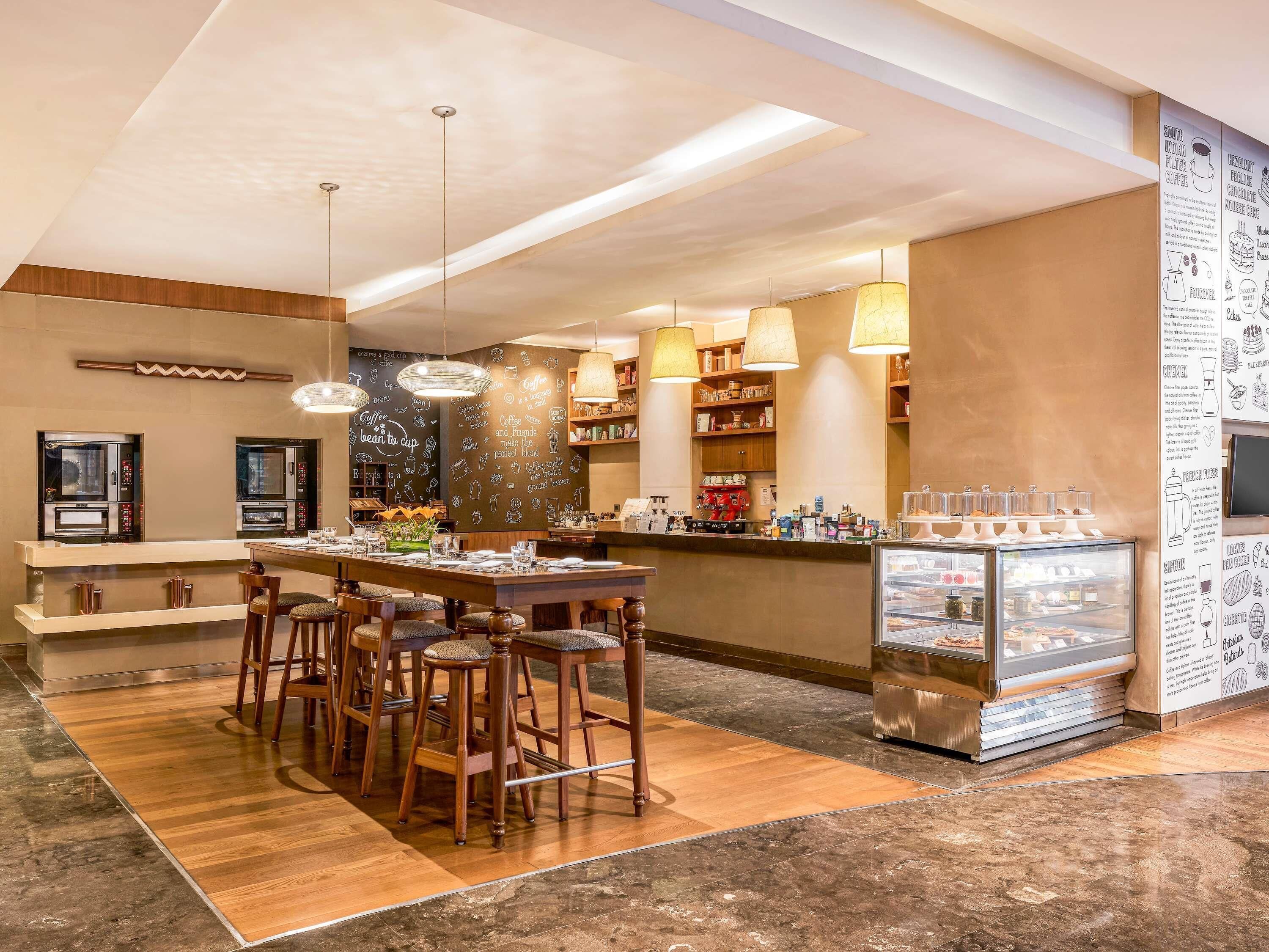 Un interno di una caffetteria moderna con un bancone, posti a sedere e una vetrina.