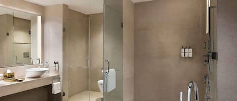 A modern bathroom with a freestanding bathtub, a glass-enclosed shower, and a vanity with a large mirror.