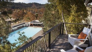 A wooden deck with white chairs and a pool. - Indian Springs Resort & Spa (Calistoga)