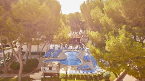 A pool area with lounge chairs and a small pool, surrounded by trees. - MLL Palma Bay Club Resort Hotel (Palma de Mallorca)