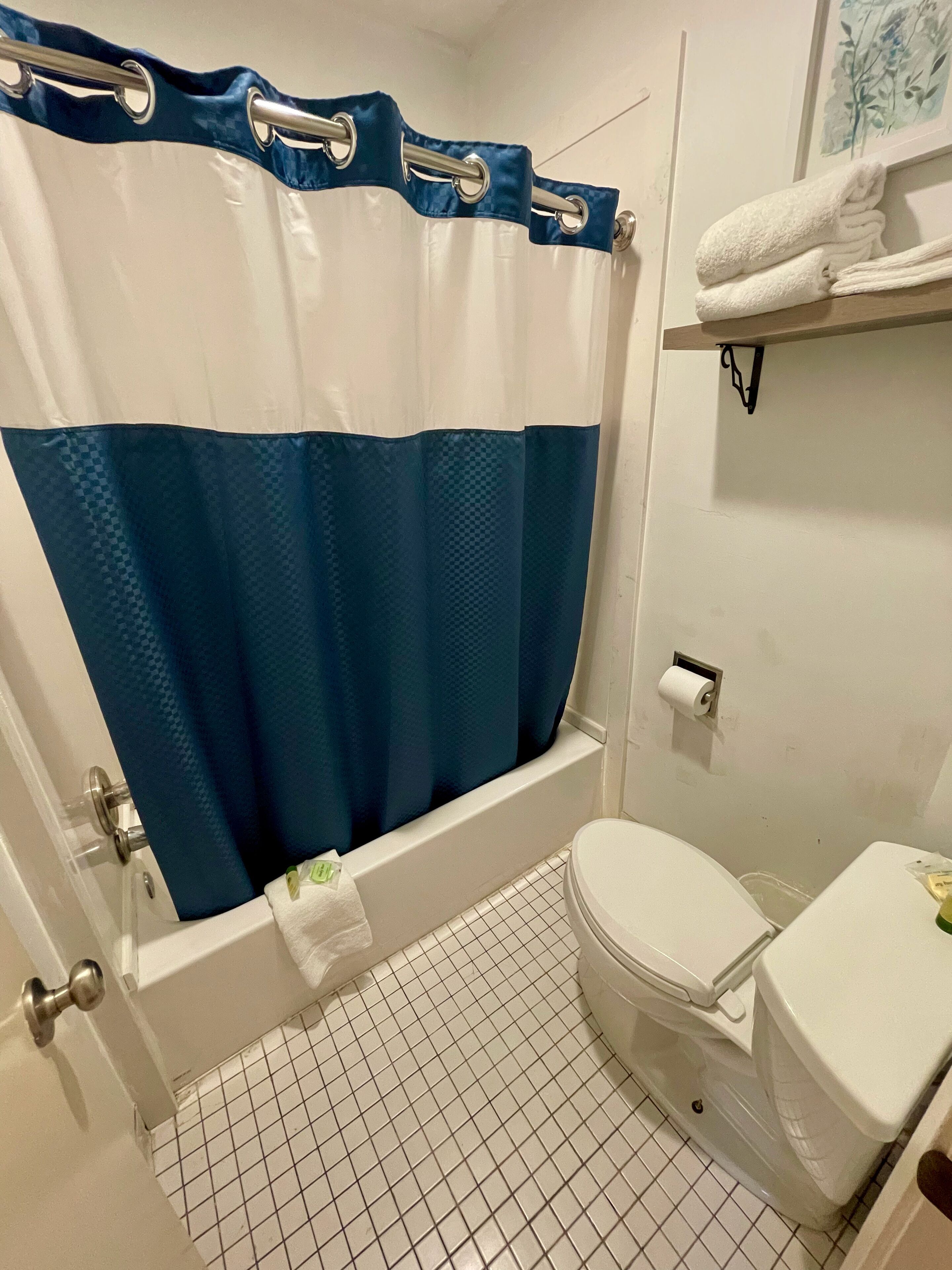 Un baño con bañera, inodoro y un perchero para toallas.