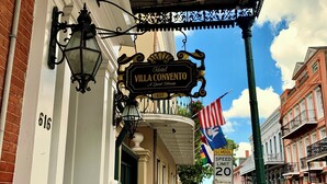 A hotel sign reading "Villa Convento" with a classic lamp and a number "616" on the building. - Hotel Villa Convento (New Orleans)