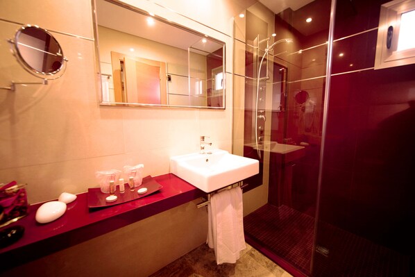 A modern bathroom with a white sink, a large mirror, and a glass-enclosed shower. - MLL Mediterranean Bay Hotel - Adults Only (Llucmajor)