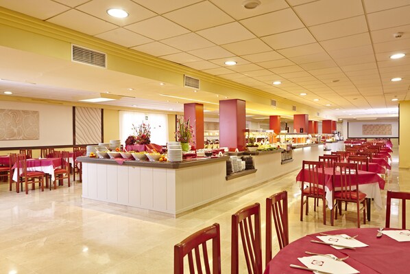 A spacious dining area with multiple tables and chairs, a central buffet station, and a clean, well-lit environment. - MLL Sahara Nubia Gobi Bay Hotel (Palma de Mallorca)