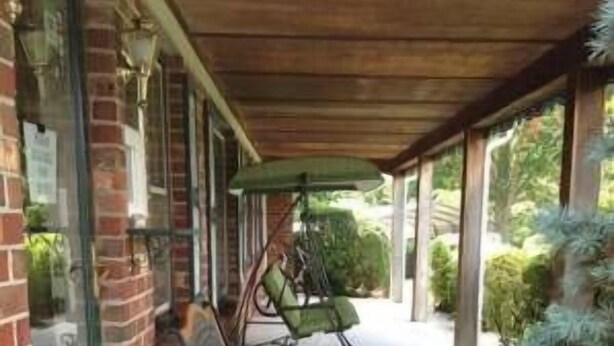 A covered outdoor seating area with benches and a sheltered entrance to a building. - Village Inn (Lovingston)