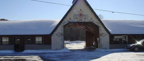 A building with a snow-covered roof and an ornate entrance archway.