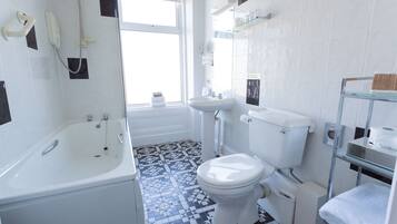 A bathroom with a bathtub, toilet, and sink.