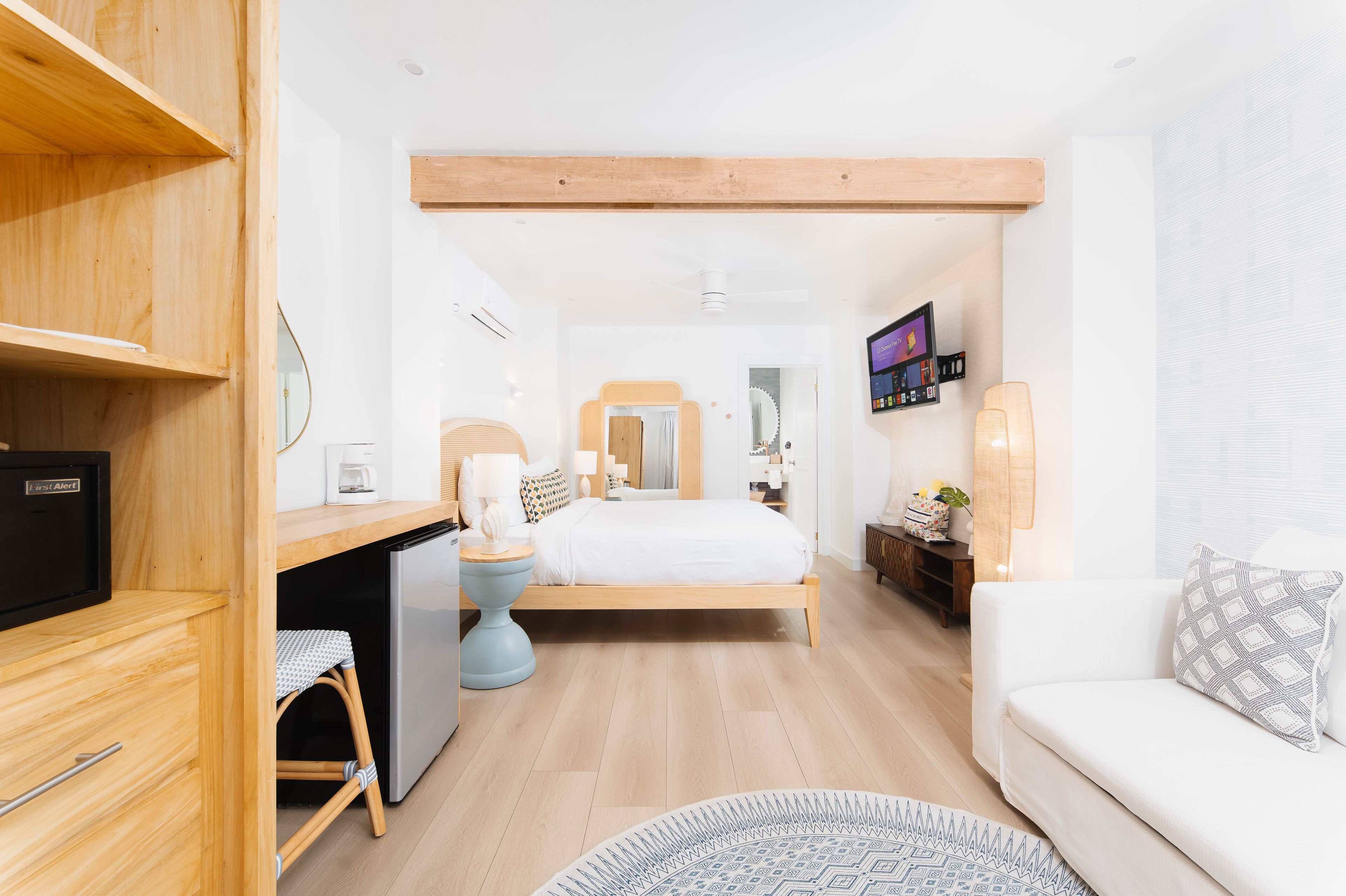 Ein modernes Schlafzimmer mit Bett, Nachttisch, Schreibtisch und einer kleinen Sitzecke.