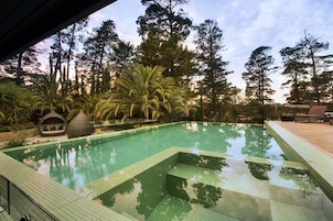 Una piscina al aire libre, sillones reclinables de piscina