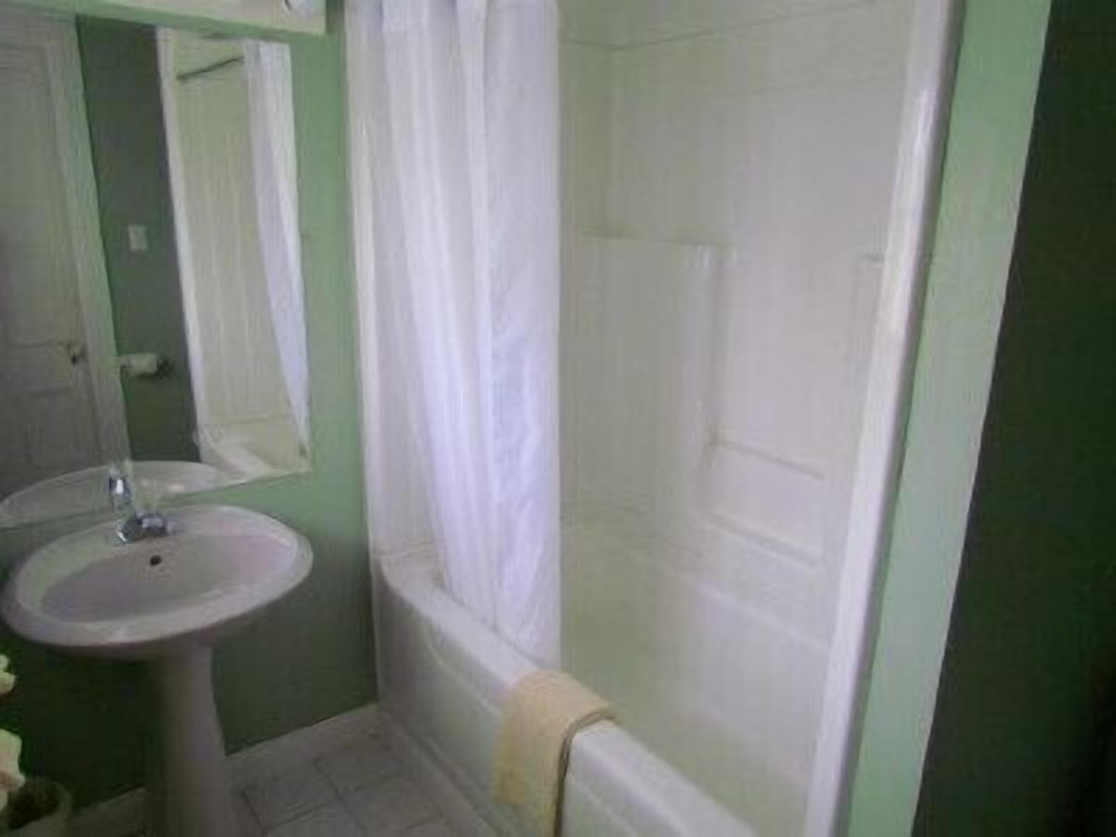 Un baño con lavamanos, espejo y ducha.