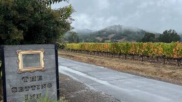 A sign for "The Setting Inn" with a view of a vineyard and hills in the background.