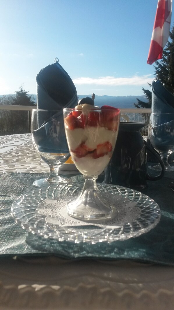 Un dessert in un bicchiere su un tavolo con vista sulle montagne.