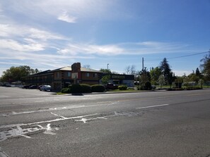 A motel with a parking lot, a Dollar General store, and a clear sky.