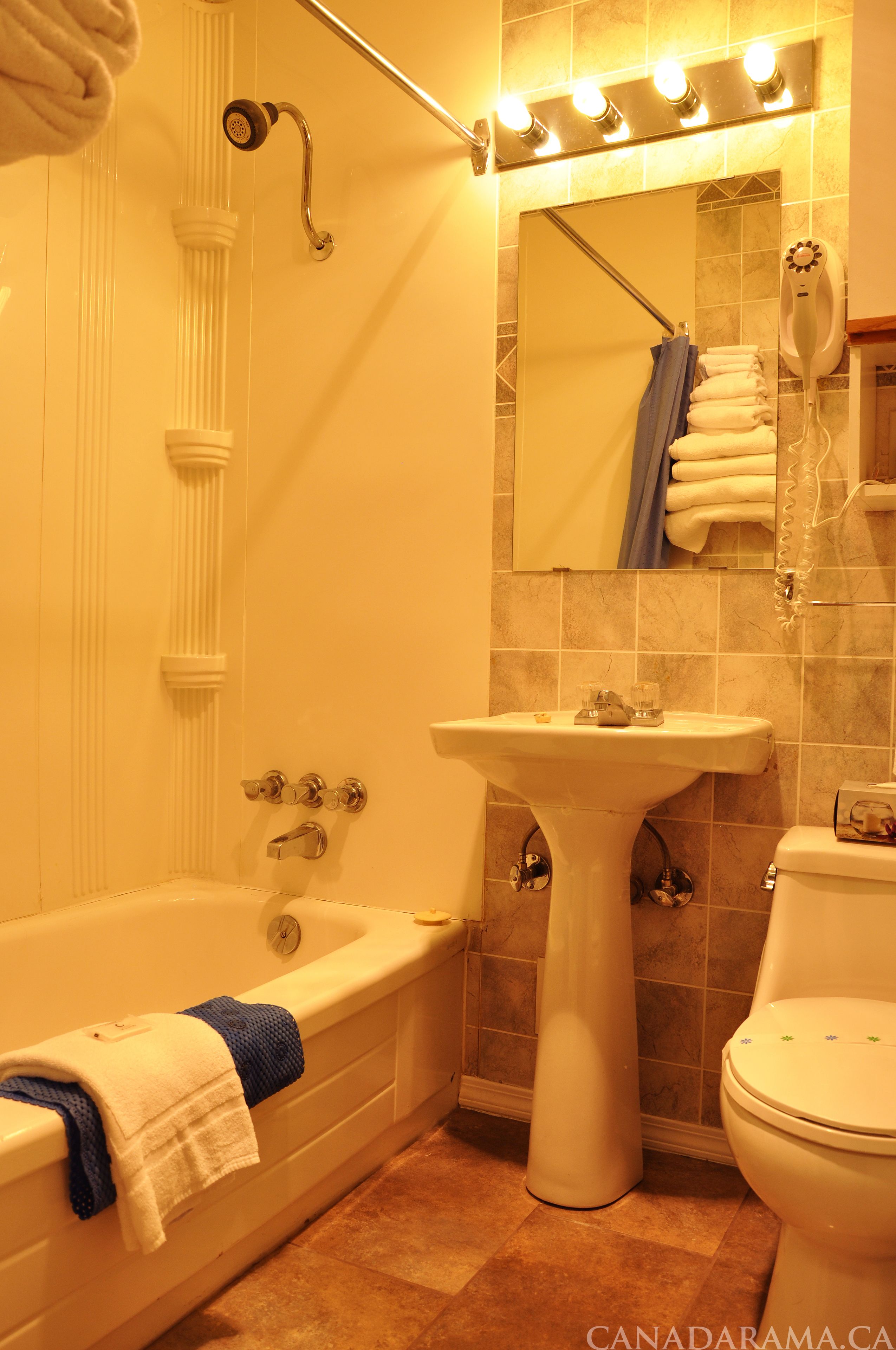 Un baño con bañera, lavabo, inodoro y espejo.