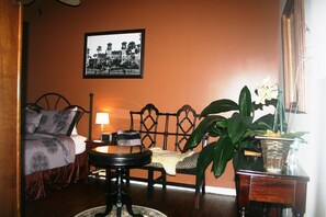 A room with a bed, a chair, a table, and a potted plant. - Old City House Inn and Restaurant (St. Augustine)