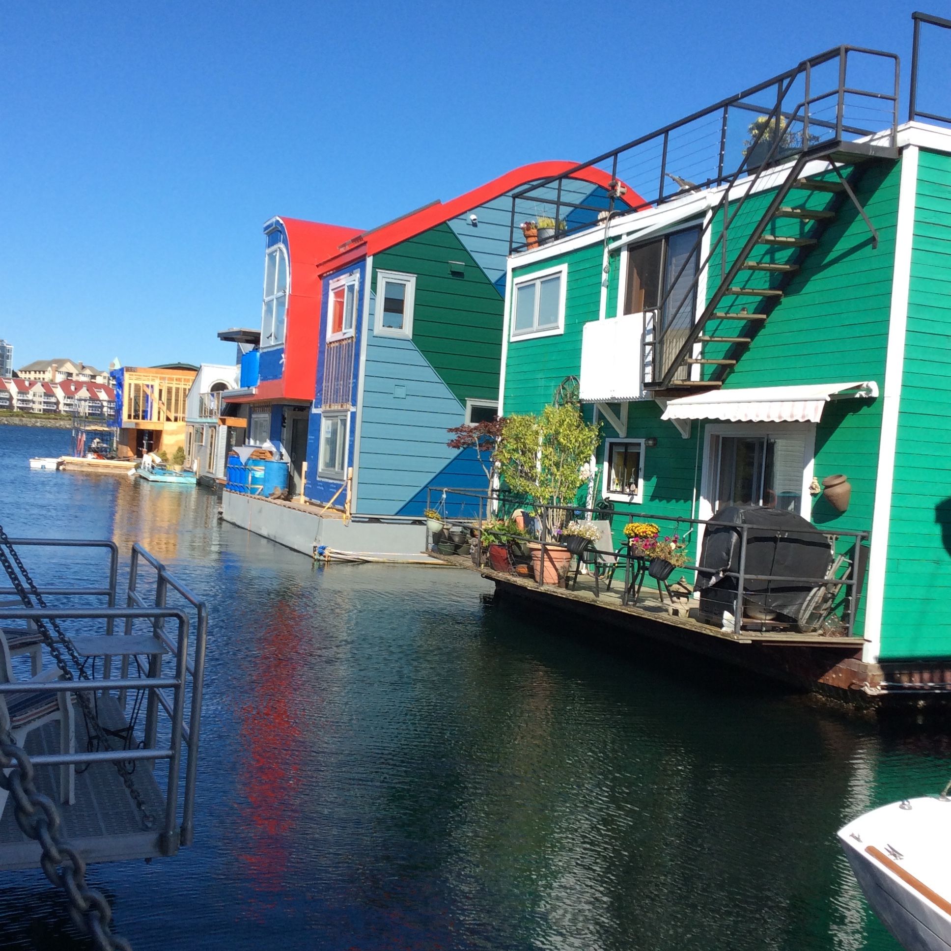 A waterfront property with a dock, a boat, and colorful buildings.