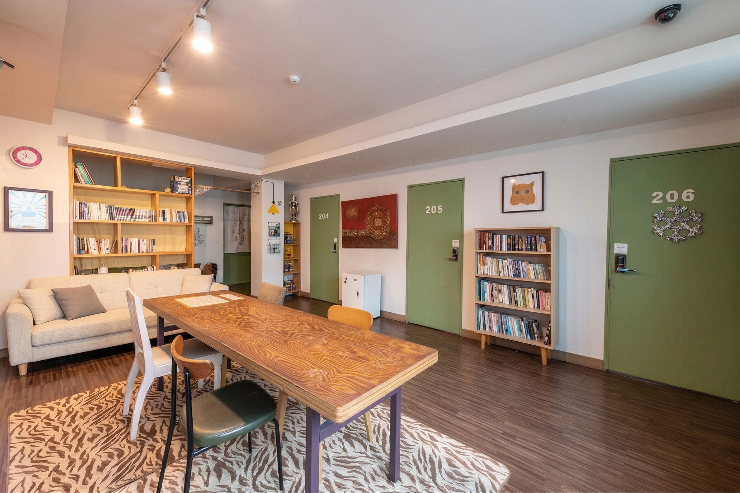 Ein modernes Wohnzimmer mit einem Holzesstisch, einer Couch und Bücherregalen.